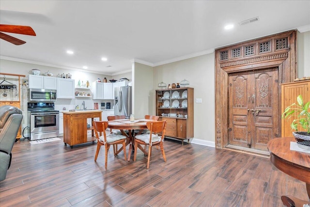 dining space featuring crown molding, a ceiling fan, dark wood-style floors, and visible vents
