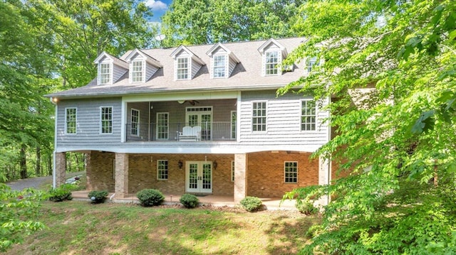 view of front of house with brick siding, ceiling fan, french doors, and a patio area