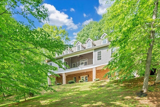 rear view of property featuring french doors, ceiling fan, and brick siding