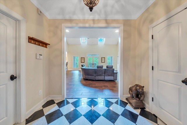 foyer entrance featuring crown molding and baseboards