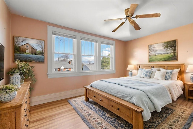 bedroom featuring light wood finished floors, baseboards, and ceiling fan