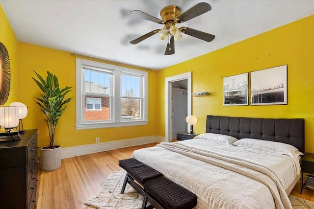 bedroom featuring baseboards, wood finished floors, and ceiling fan