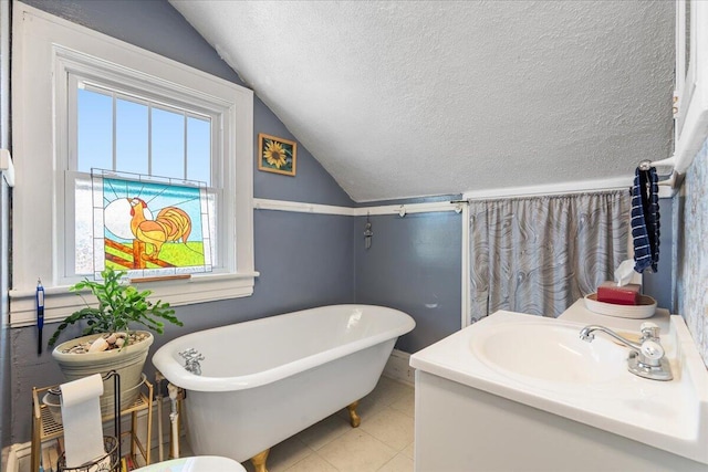 full bath with vaulted ceiling, a textured ceiling, a freestanding tub, tile patterned floors, and vanity