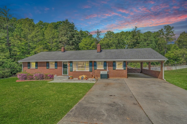 single story home with an attached carport, fence, a chimney, a front lawn, and driveway