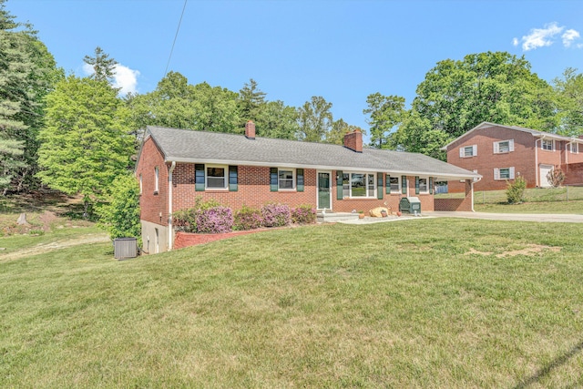 ranch-style house with a front lawn, concrete driveway, brick siding, and a chimney