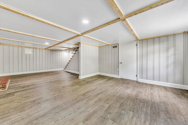 interior space featuring stairs, baseboards, visible vents, and wood finished floors