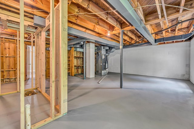 unfinished basement featuring heating unit and concrete block wall