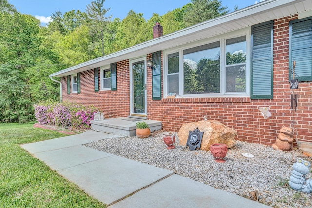 view of front of property with a chimney and brick siding