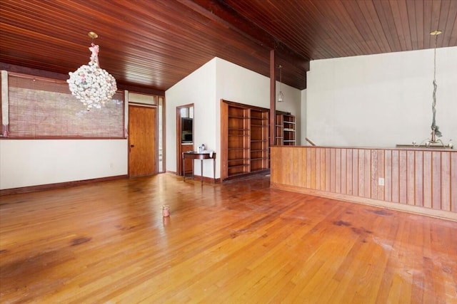 unfurnished room with wooden ceiling, baseboards, an inviting chandelier, vaulted ceiling, and hardwood / wood-style floors