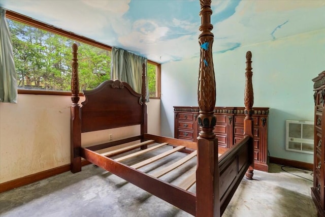 bedroom with baseboards, heating unit, and concrete flooring