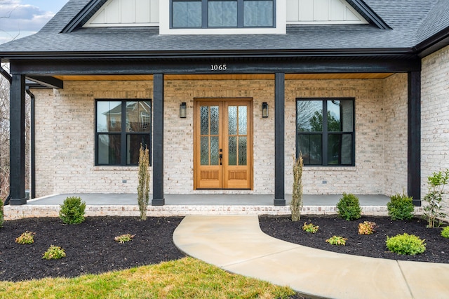 1065 Cedar Fox Ct, Forest, VA 24551 - view of exterior entry with board and batten siding, a porch, roof with shingles, and brick siding