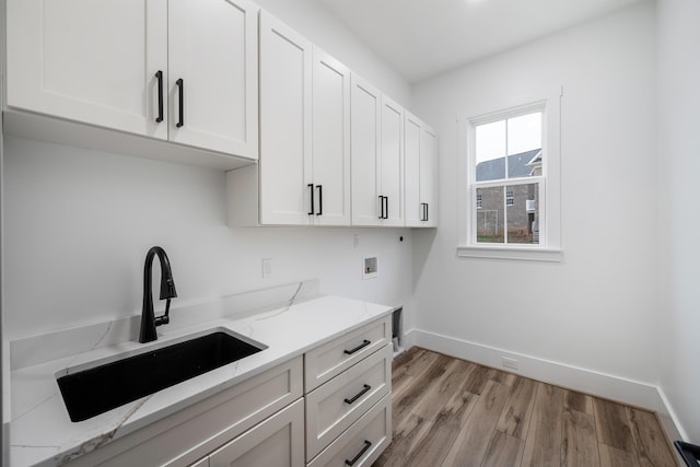 1065 Cedar Fox Ct, Forest, VA 24551 - clothes washing area featuring light wood-style flooring, a sink, cabinet space, hookup for a washing machine, and baseboards