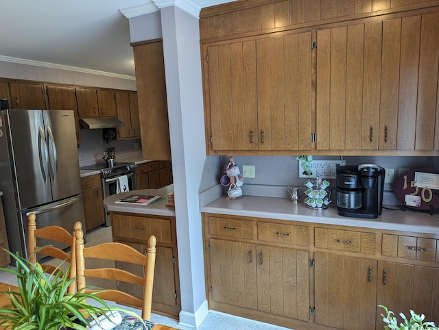kitchen featuring brown cabinets, light countertops, appliances with stainless steel finishes, and under cabinet range hood