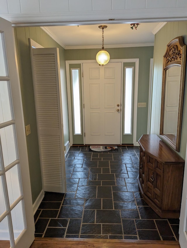 foyer entrance featuring crown molding, a healthy amount of sunlight, and stone tile floors