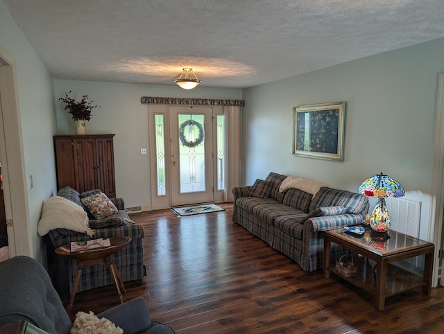 living area featuring visible vents, a textured ceiling, and wood finished floors