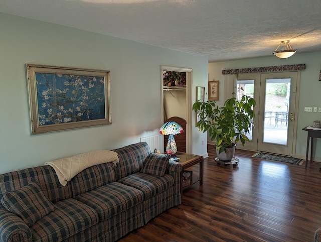 living area with a textured ceiling and wood finished floors