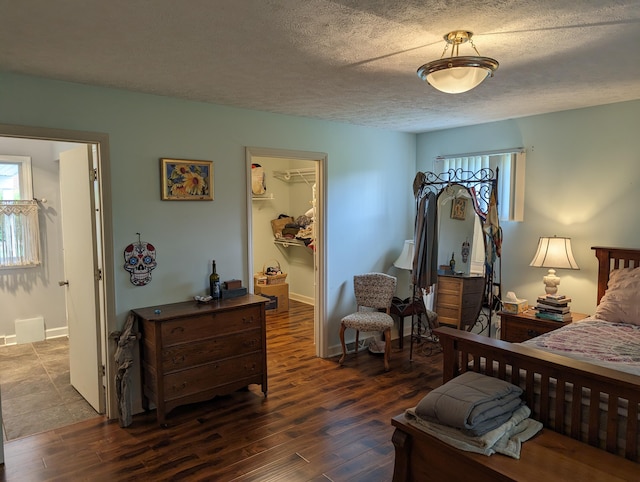 bedroom featuring multiple windows, a spacious closet, a closet, and wood finished floors