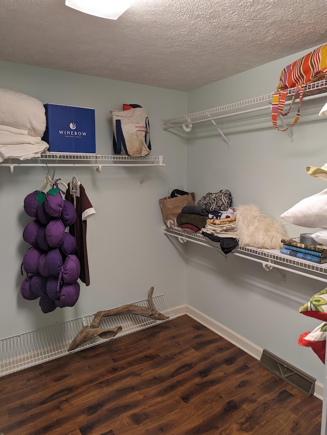 spacious closet featuring visible vents and wood finished floors