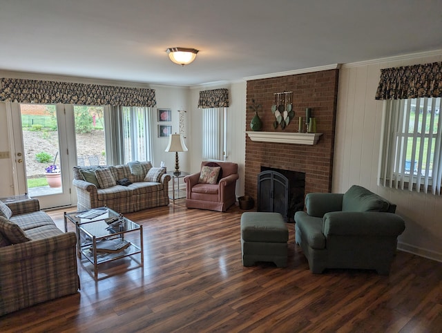 living area with ornamental molding, wood finished floors, and a brick fireplace