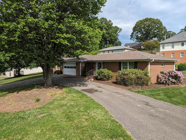 view of front of property with a front yard, brick siding, a garage, and aphalt driveway