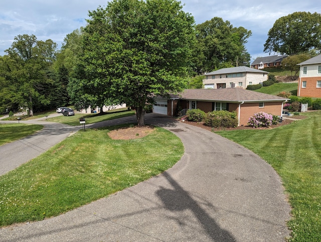 view of front of property with a garage, brick siding, driveway, and a front yard