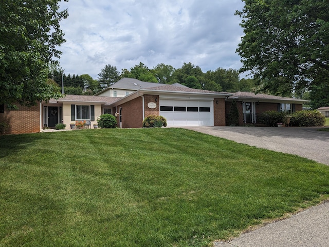 single story home with an attached garage, brick siding, a front lawn, and aphalt driveway