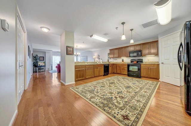 1100 Celebration Ave Unit 405, Moneta, VA 24121 - kitchen with black appliances, brown cabinetry, light wood-style floors, decorative light fixtures, and a chandelier