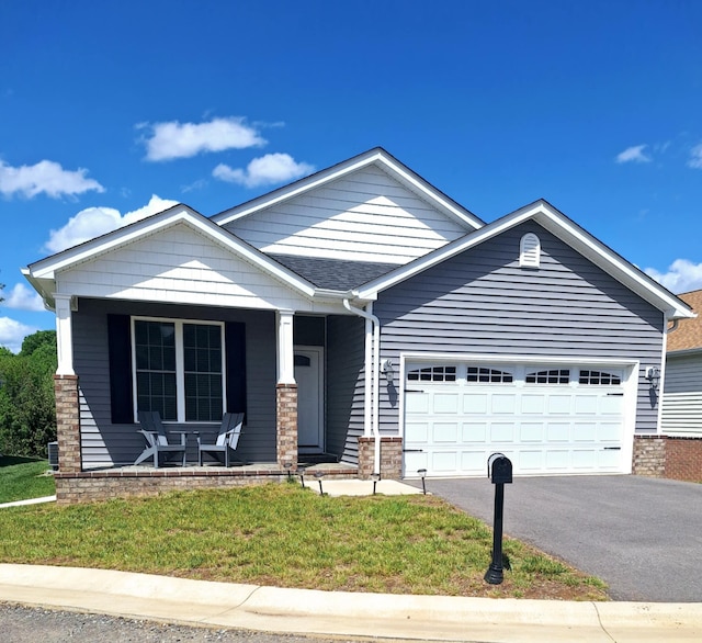 view of front of house with an attached garage, a porch, driveway, and a front lawn