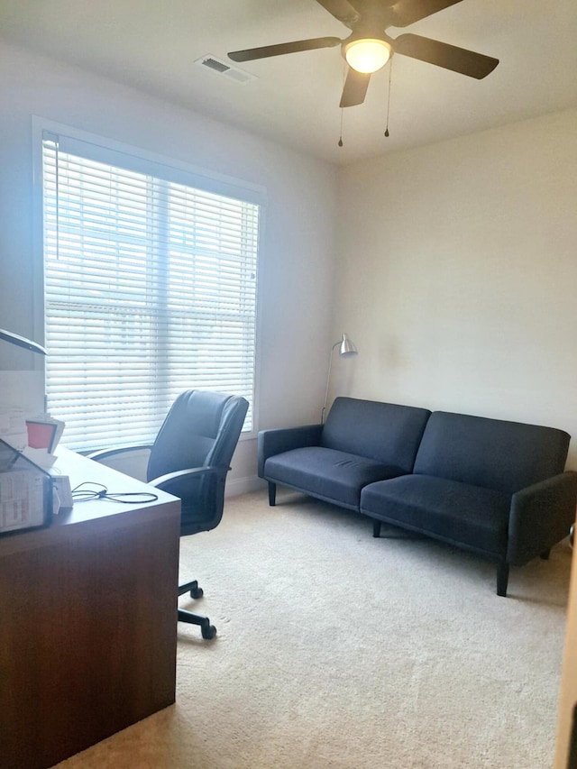 office space featuring a ceiling fan, carpet flooring, and visible vents