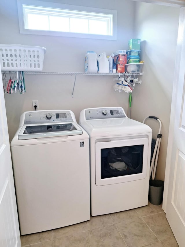 laundry area featuring washing machine and clothes dryer and light tile patterned flooring