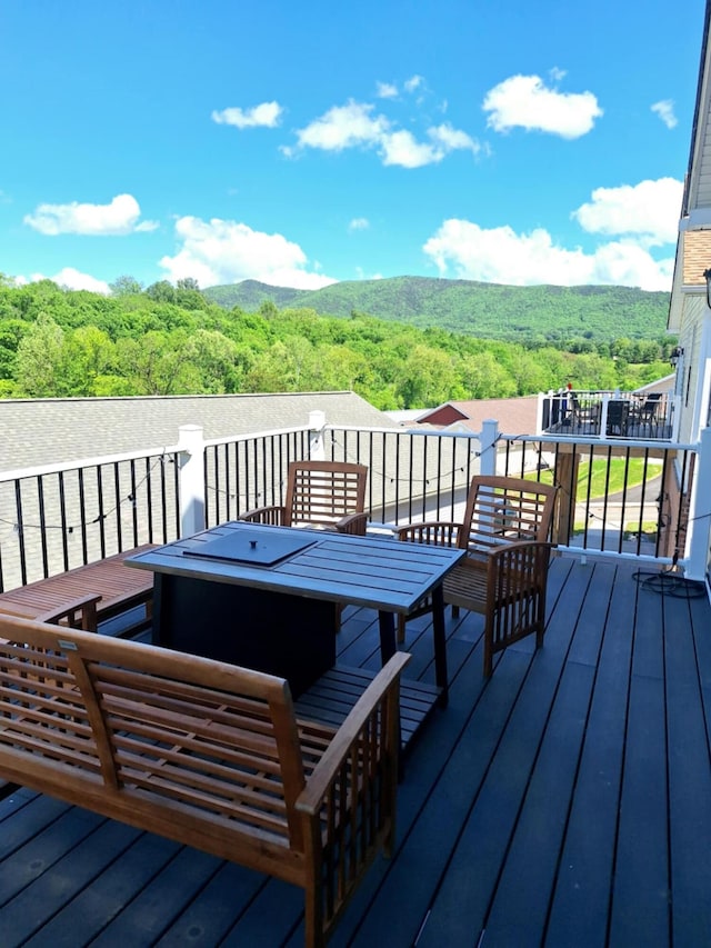 wooden terrace featuring a forest view