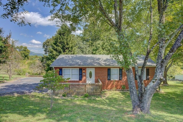 single story home featuring a front lawn, brick siding, and aphalt driveway