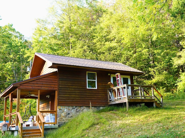 195 Lost Spring Ln, Lexington, VA 24450 - view of front of property featuring a forest view, a wooden deck, a front yard, ceiling fan, and roof with shingles