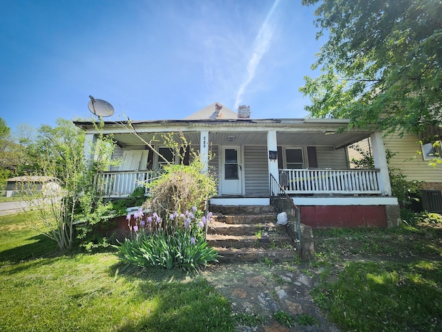 view of front of property with a porch, central air condition unit, a chimney, and a front yard