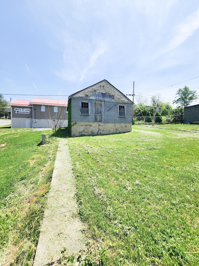 view of front facade featuring a front yard and concrete block siding