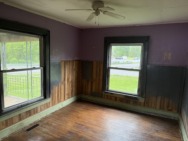 2807 S Carpenter Dr, Covington, VA 24426 - empty room featuring wood walls, a wainscoted wall, visible vents, and wood finished floors