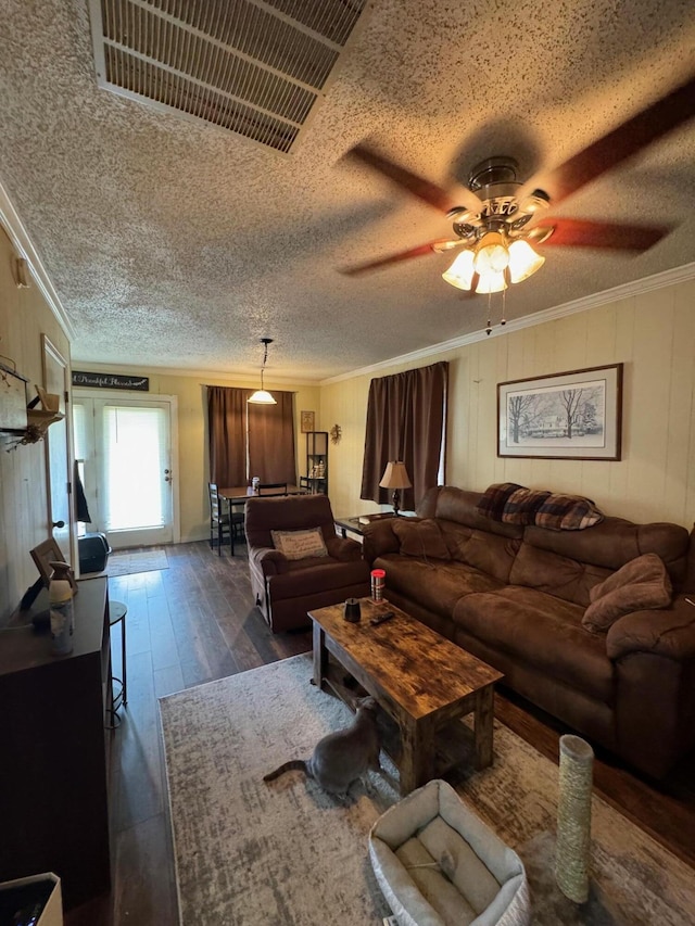 living room featuring crown molding, a textured ceiling, visible vents, ceiling fan, and dark wood-style floors