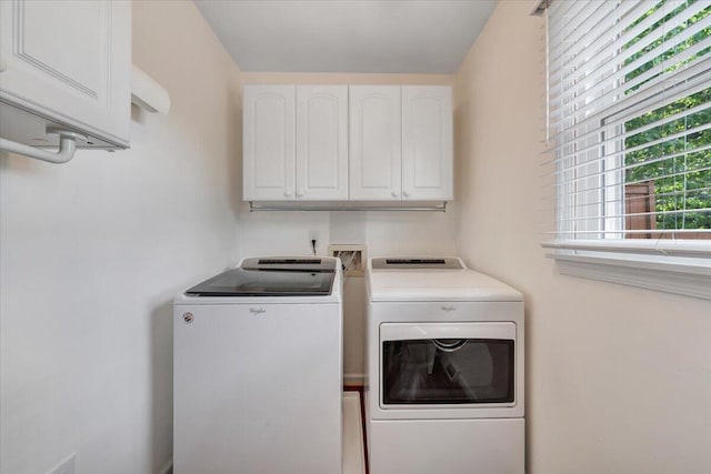 laundry room with separate washer and dryer and cabinet space