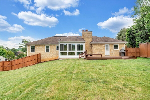 rear view of house with a deck, brick siding, and a chimney