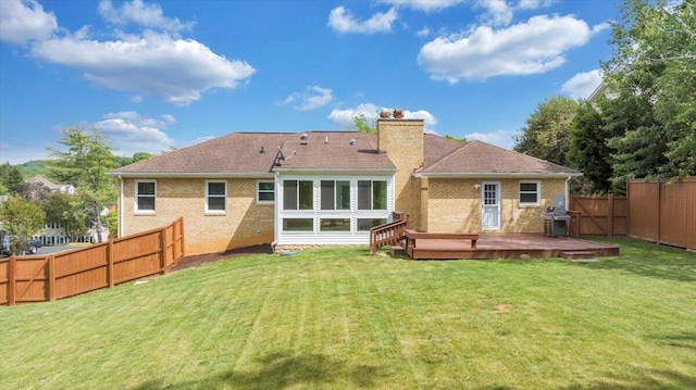 rear view of house featuring a chimney, a wooden deck, and brick siding