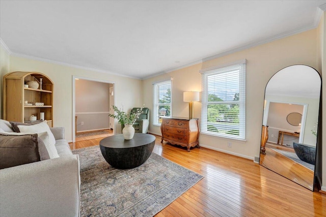 living room featuring ornamental molding, light wood finished floors, and baseboards