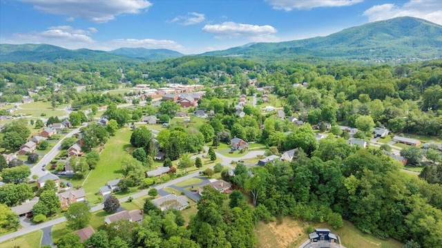 aerial view of residential area featuring mountains and a heavily wooded area