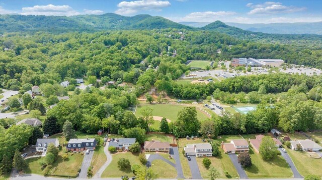 aerial view of residential area with a heavily wooded area and a mountain backdrop