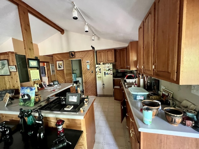 kitchen with white refrigerator with ice dispenser, brown cabinets, light floors, light countertops, and wood walls