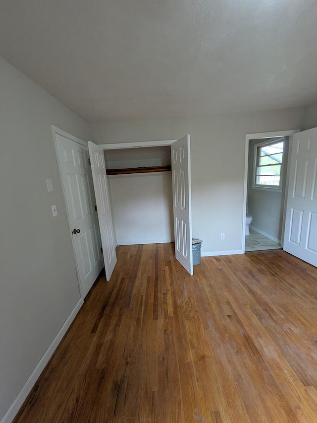 58 Lakeland Cir, Troutville, VA 24175 - unfurnished bedroom with ensuite bathroom, baseboards, a closet, and wood finished floors