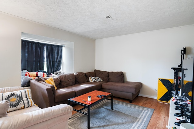 living area featuring a textured ceiling, visible vents, and wood finished floors
