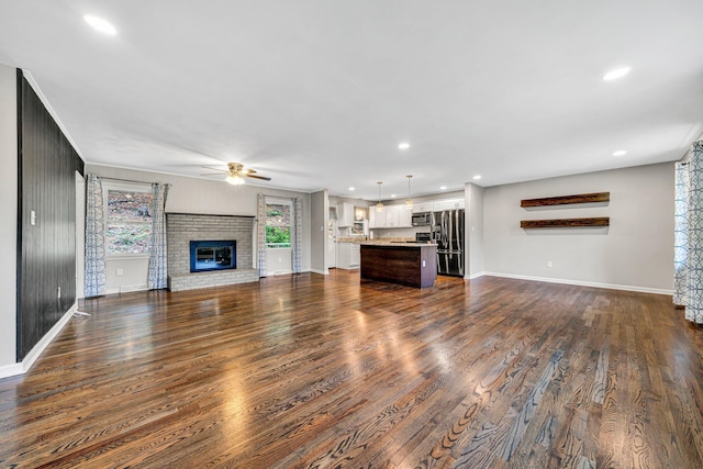 3443 Overhill Trl, Roanoke, VA 24018 - unfurnished living room featuring a ceiling fan, a brick fireplace, baseboards, dark wood finished floors, and recessed lighting