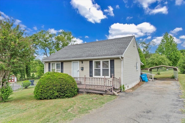 view of front facade featuring a front yard, a detached carport, asphalt driveway, roof with shingles, and crawl space