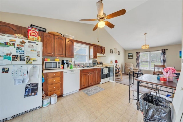 kitchen featuring white appliances, vaulted ceiling, light countertops, light flooring, and a ceiling fan