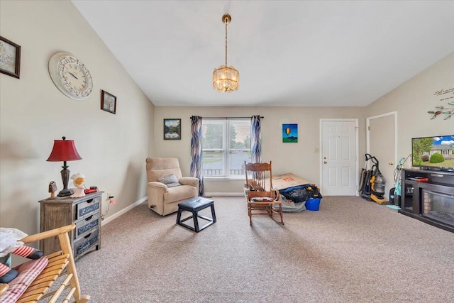 carpeted living room featuring a chandelier and baseboards
